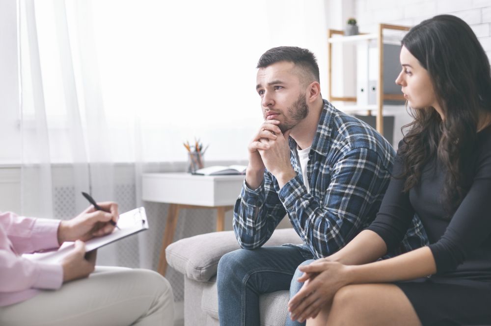 Couple sitting on a couch during a counseling session with a therapist, focusing on relationship support for first responders