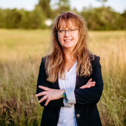 image of a woman cross-armed in the field